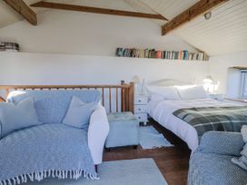 A bedroom with a bed and sofa at The Little Barn in Fluxton Nr. Ottery St Mary