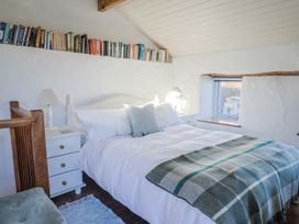 A bedroom with a bed and bookshelf at The Little Barn in Fluxton Nr. Ottery St Mary