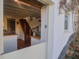 A kitchen with a staircase visible from the entrance at The Little Barn in Fluxton Nr. Ottery St Mary