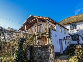 A house with a balcony and steps surrounded by greenery at The Little Barn Fluxton Nr. Ottery St Mary