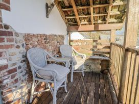 A balcony with wicker chairs and a wooden floor at The Little Barn Fluxton Nr. Ottery St Mary