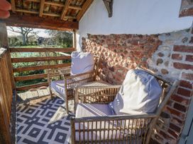 An outdoor area with two wicker chairs and a rug at The Little Barn Fluxton Nr. Ottery St Mary