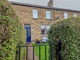 An exterior view of a house with a pathway and hedges at 23 Northumbria Terrace Amble