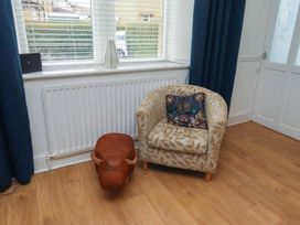 A living room with a chair and decorative objects at 23 Northumbria Terrace in Amble