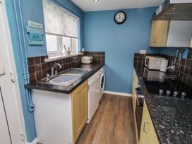 A kitchen with a sink and appliances at 23 Northumbria Terrace Amble