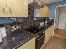 A kitchen with cabinets and a stove at 23 Northumbria Terrace Amble