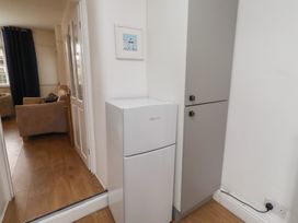 A kitchen with a refrigerator and cabinets at 23 Northumbria Terrace Amble