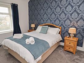 A bedroom with a double bed and bedside table at 23 Northumbria Terrace in Amble
