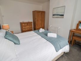 A bedroom with a bed and wooden furniture at 23 Northumbria Terrace in Amble
