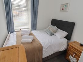 A bedroom with a bed and towels on it at 23 Northumbria Terrace Amble