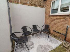 An outdoor seating area with four chairs and a rug at 23 Northumbria Terrace Amble