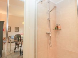A shower with a glass door and shelves at Woodcock Studio Andoversford near Cheltenham