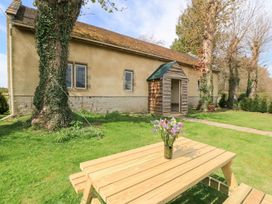 A table with flowers in front of a building at Woodcock Studio in Andoversford near Cheltenham