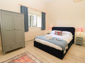 A bedroom with a bed and wardrobe at Swallow Studio in Andoversford near Cheltenham