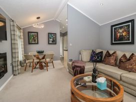 A living room with a sofa and dining table at 32 Grasmere, White Cross Bay near Windermere