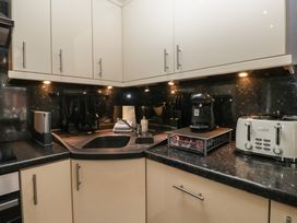 A kitchen with cabinets, sink, coffee maker, and toaster at 32 Grasmere, White Cross Bay near Windermere