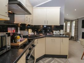 A kitchen with appliances and utensils at 32 Grasmere, White Cross Bay near Windermere