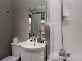 A bathroom with a toilet, wash basin, and shower at 32 Grasmere, White Cross Bay near Windermere