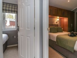 A bedroom with a door and window view at 32 Grasmere, White Cross Bay near Windermere