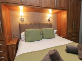A bedroom with a bed and wardrobe at 32 Grasmere, White Cross Bay near Windermere