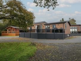 A house with a deck and trees in the outdoor area at 7 Lake View Windermere