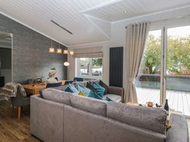 A living room with a dining table and sofa at 7 Lake View, Windermere