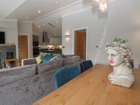 A living room with a dining table and a kitchen view at 7 Lake View Windermere