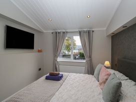 A bedroom with a bed and television at 7 Lake View in Windermere
