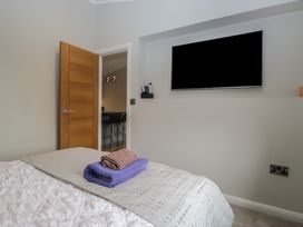 A bedroom with a bed and towels in the foreground at 7 Lake View Windermere