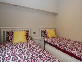 A bedroom with two beds and a nightstand at 7 Lake View in Windermere