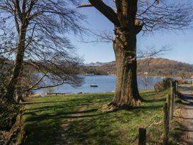 A view of a lake with a tree and boat at 7 Lake View in Windermere
