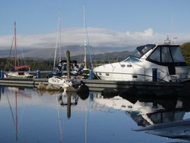 A dock with boats reflected in water at 7 Lake View in Windermere