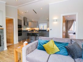 A living room with a sofa and kitchen area at 7 Lake View, Lake View 7, White Cross Bay near Windermere