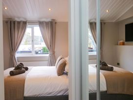 A bedroom with a bed and window at 7 Lake View, White Cross Bay near Windermere