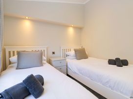 A bedroom with two beds and a bedside table at 7 Lake View, Lake View 7, White Cross Bay near Windermere