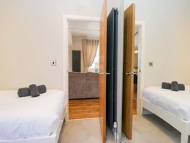 A bedroom with two beds and a view into the living room at 7 Lake View, Lake View 7, White Cross Bay near Windermere