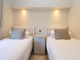 A bedroom with two beds and a nightstand at 7 Lake View, Lake View 7, White Cross Bay near Windermere