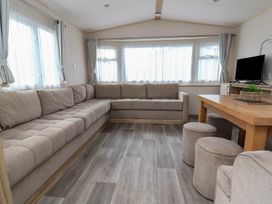 A living room with a sofa and table at E10 Static Caravan in Rhyl