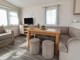 A living room with a television and table at E10 Static Caravan in Rhyl