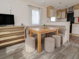 A dining area with a table and sofas at E10 Static Caravan Rhyl