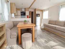A living room with a table and sofa at E10 Static Caravan in Rhyl