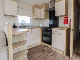 A kitchen with cabinets and appliances at E10 Static Caravan Rhyl
