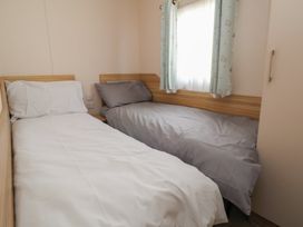 A bedroom with two beds and a window at E10 Static Caravan Rhyl