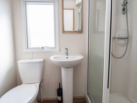 A bathroom with a sink, toilet, and shower at E10 Static Caravan, Rhyl