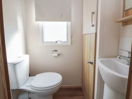 A bathroom with a toilet and sink at E10 Static Caravan in Rhyl