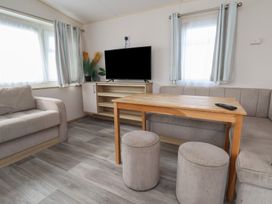 A living room with a sofa and TV at A5 Static Caravan in Rhyl