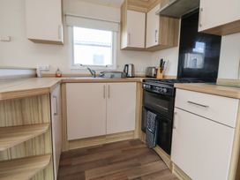 A kitchen with a stove and sink at A5 Static Caravan in Rhyl