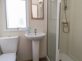 A bathroom with a toilet, sink, and shower at A5 Static Caravan Rhyl