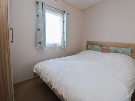 A bedroom with a double bed and window at A5 Static Caravan Rhyl