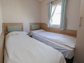 A bedroom with two beds and a window at A5 Static Caravan Rhyl